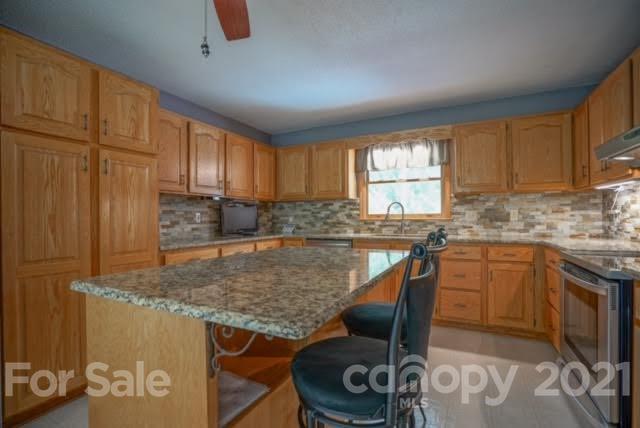 9675 Mt Olive Road Mount Pleasant, NC 28124 - Photo 20 of 48 a kitchen with granite countertop a stove a sink a window and a dining table