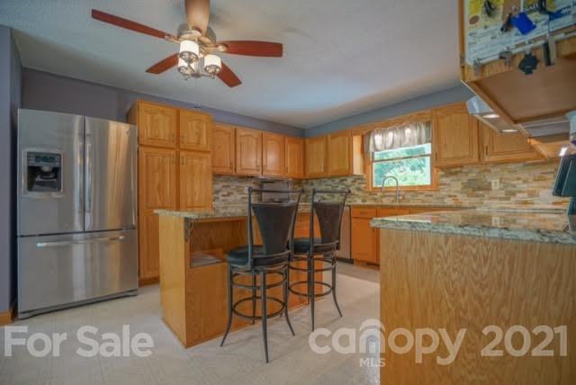 9675 Mt Olive Road Mount Pleasant, NC 28124 - Photo 21 of 48 a kitchen with stainless steel appliances granite countertop a refrigerator a stove a sink dishwasher and a dining table with wooden cabinet