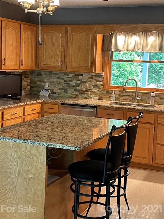9675 Mt Olive Road Mount Pleasant, NC 28124 - Photo 26 of 48 a kitchen with stainless steel appliances granite countertop wooden cabinets a stove top oven a sink with dining table and chairs