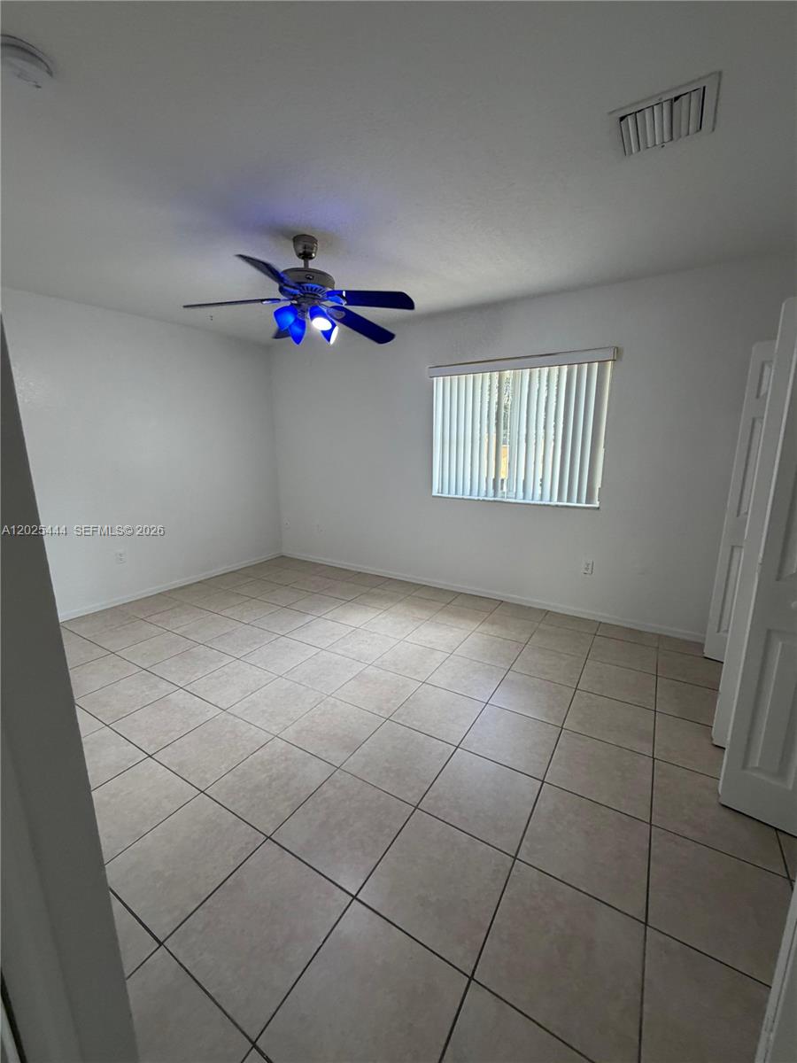 681 Southwest 7th Street, Unit 681 Florida City, FL 33034 - Photo 14 of 16 an empty room with a ceiling fan and window