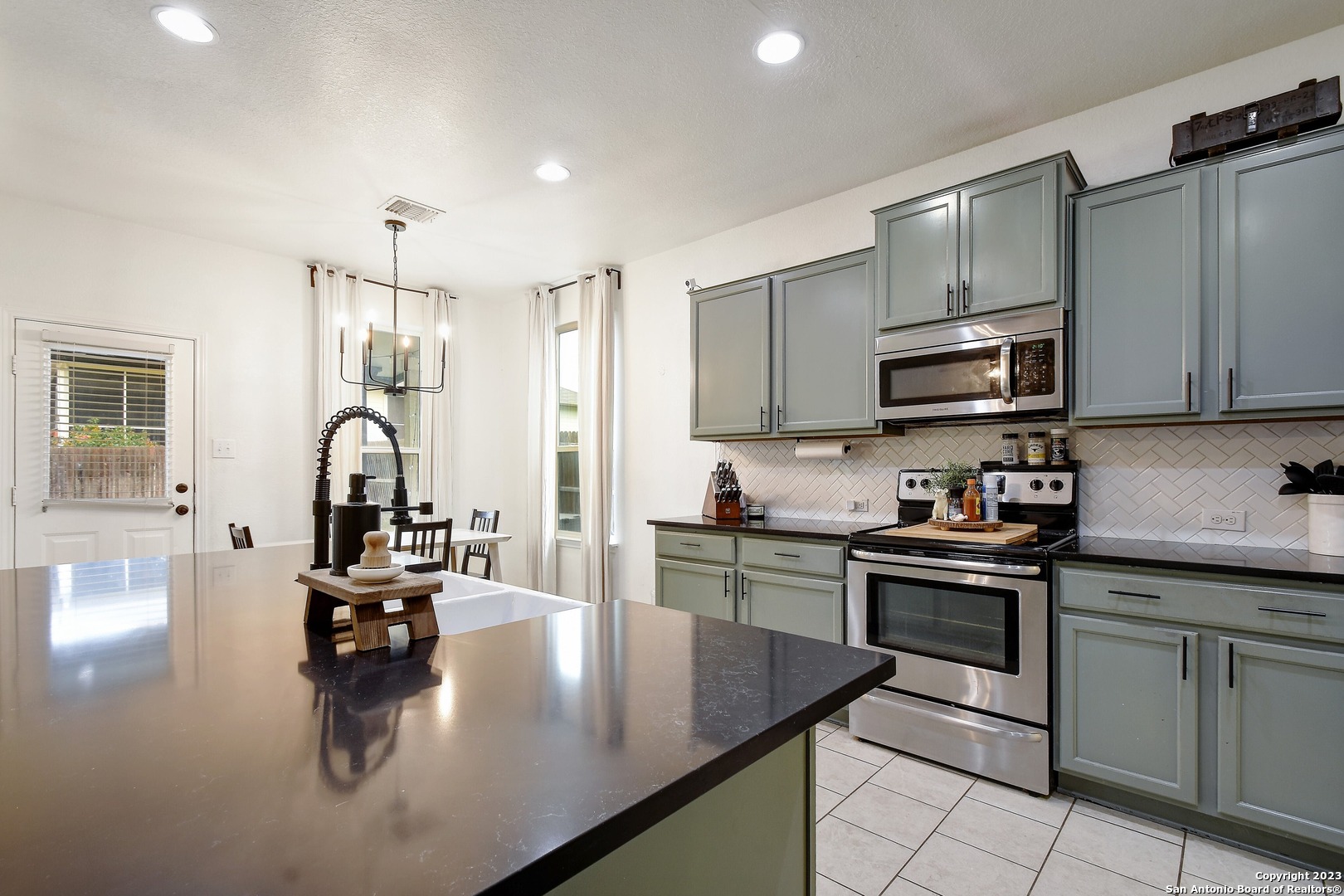 a kitchen with kitchen island granite countertop a sink stove top oven and cabinets