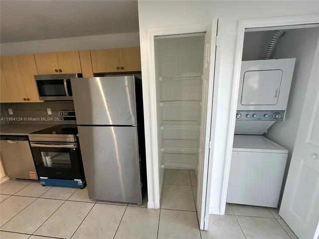 a kitchen with stainless steel appliances granite countertop a refrigerator and a stove top oven