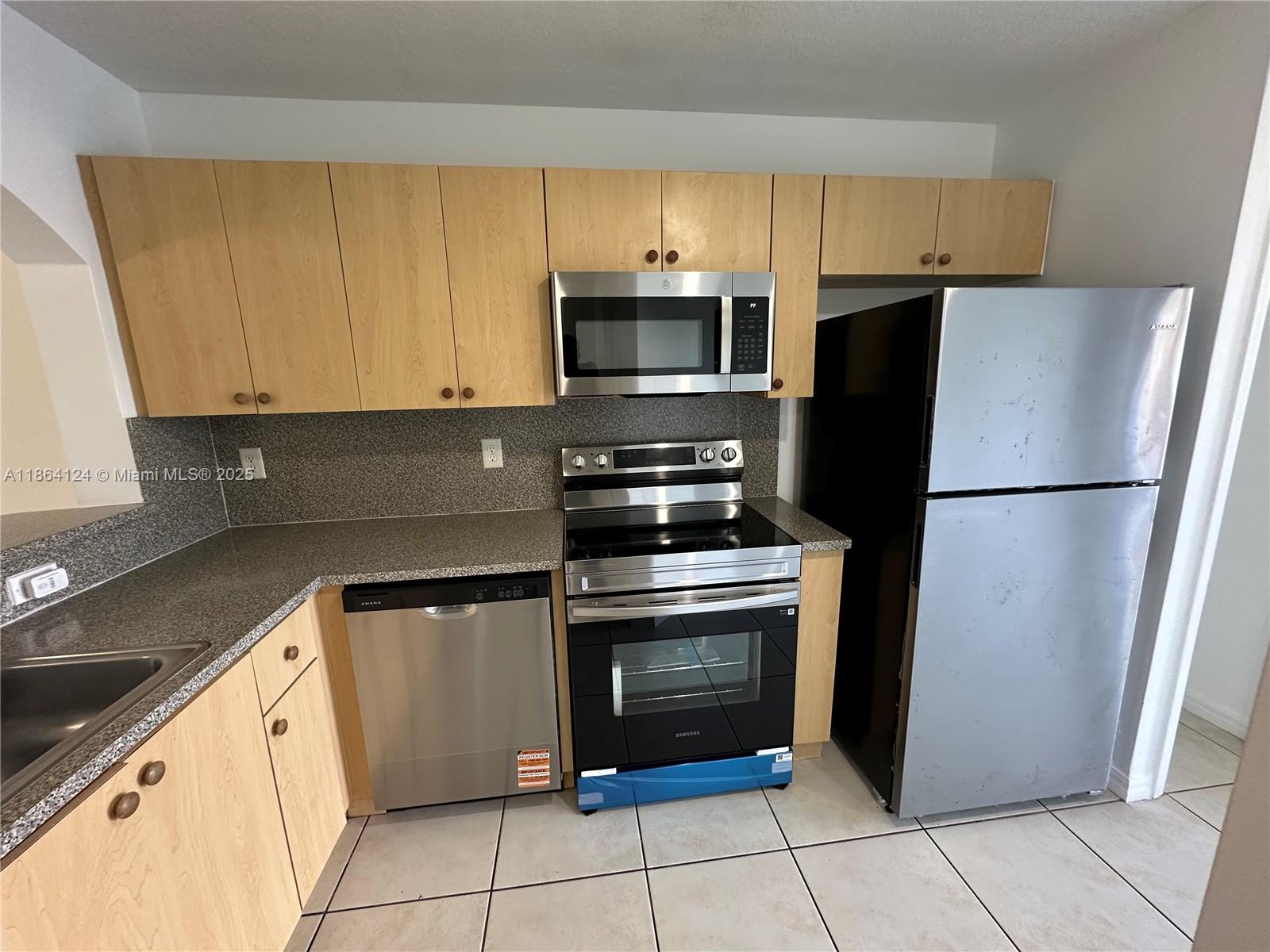 2910 Southeast 13th Avenue, Unit 10250 Homestead, FL 33035 - Photo 12 of 23 a kitchen with cabinets stainless steel appliances and a counter space