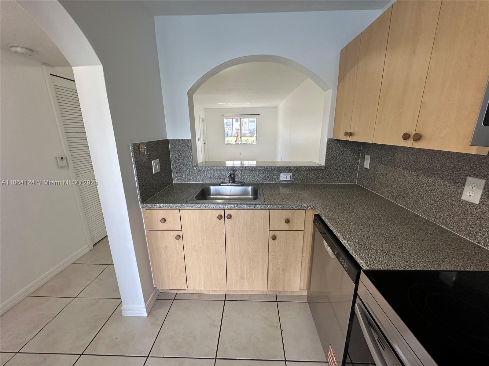 2910 Southeast 13th Avenue, Unit 10250 Homestead, FL 33035 - Photo 14 of 23 a kitchen with granite countertop white cabinets and black appliances