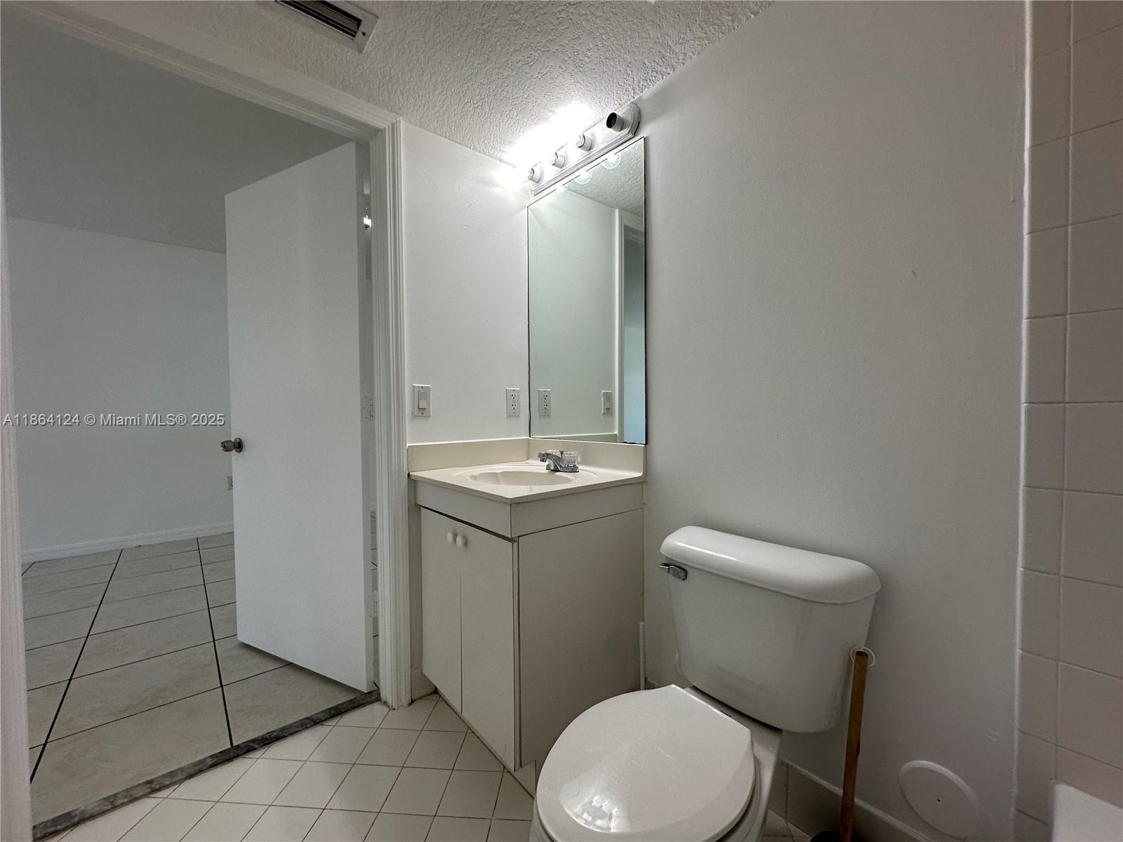 2910 Southeast 13th Avenue, Unit 10250 Homestead, FL 33035 - Photo 9 of 23 a bathroom with a toilet a sink and mirror