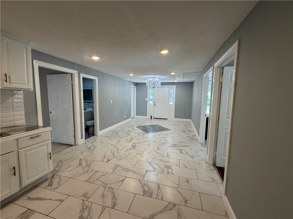 302 Sirrine Street Honea Path, SC 29654 - Photo 10 of 24 A striking chandelier illuminates the entrance foyer, boasting elegant tiled flooring throughout.