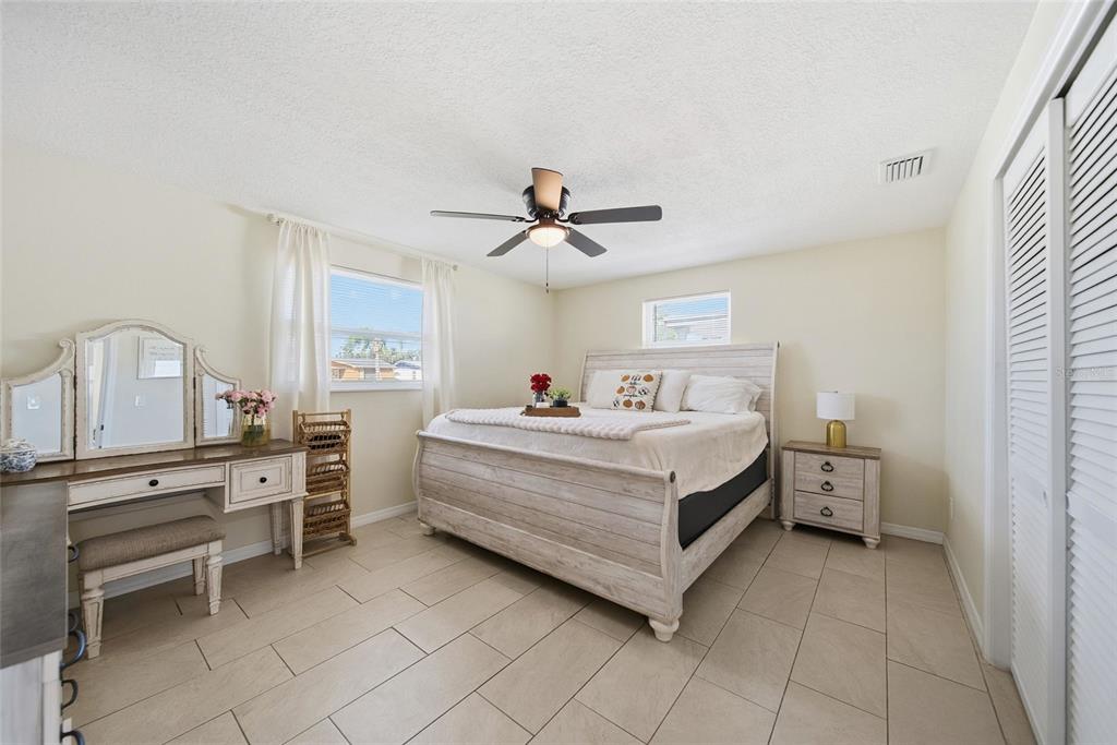 3744 Carron Street New Port Richey, FL 34652 - Photo 15 of 28 a bed room with a bed and a ceiling fan