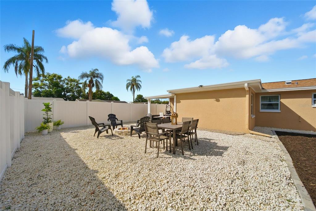 3744 Carron Street New Port Richey, FL 34652 - Photo 22 of 28 a view of a patio with table and chairs and potted plants