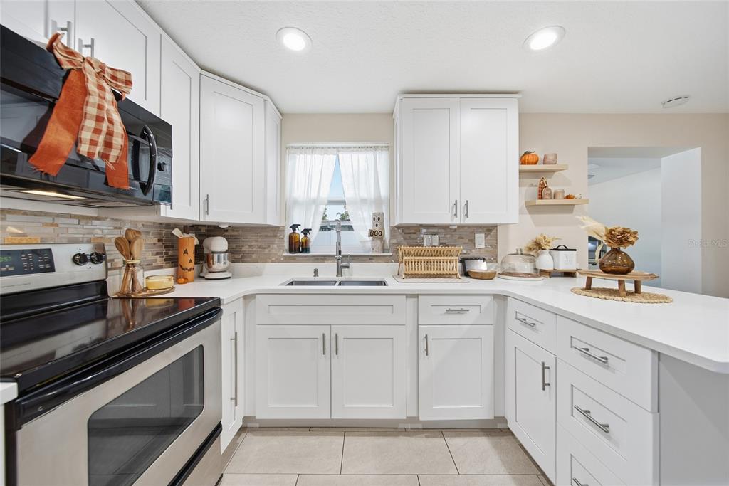 3744 Carron Street New Port Richey, FL 34652 - Photo 8 of 28 a kitchen with white cabinets appliances and a sink
