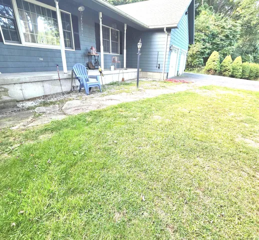 a view of a house with backyard and sitting area