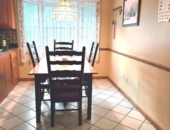 a kitchen with stainless steel appliances granite countertop a table chairs and a refrigerator
