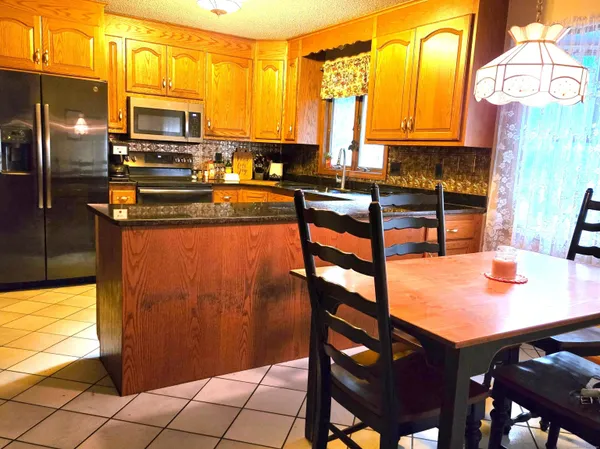 a kitchen with stainless steel appliances granite countertop a refrigerator and a sink