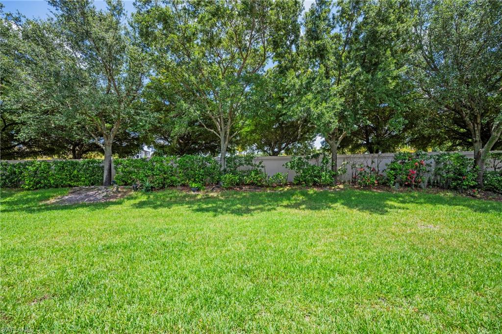 3916 Cherrybrook Loop Fort Myers, FL 33966 - Photo 21 of 31 Expansive green lawn framed by mature trees and a privacy hedge