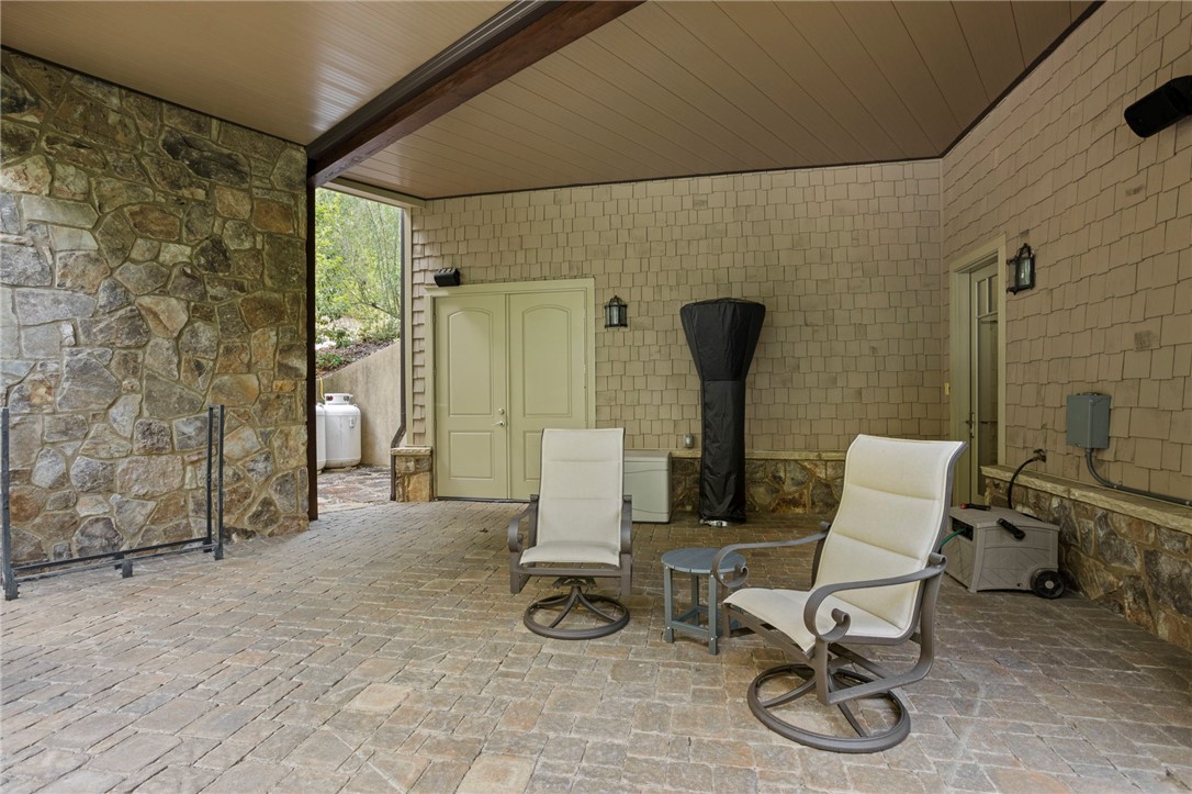 117 Sunrise Ridge Sunset, SC 29685 - Photo 27 of 44 An inviting covered patio featuring robust stone and shingle siding, perfect for relaxation.
