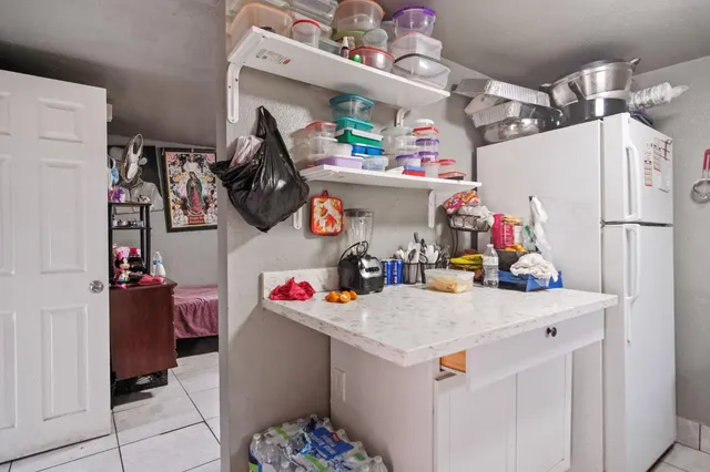 a utility room with a refrigerator and washer