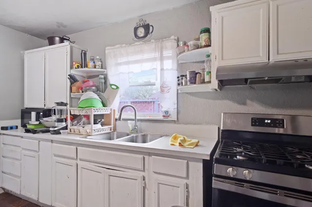 a kitchen with stainless steel appliances granite countertop a sink stove and cabinets