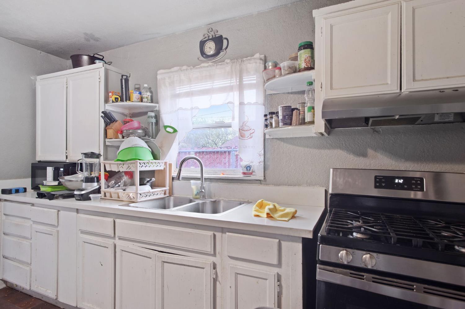1225 Eugene Avenue Modesto, CA 95351 - Photo 8 of 39 a kitchen with stainless steel appliances granite countertop a sink stove and cabinets