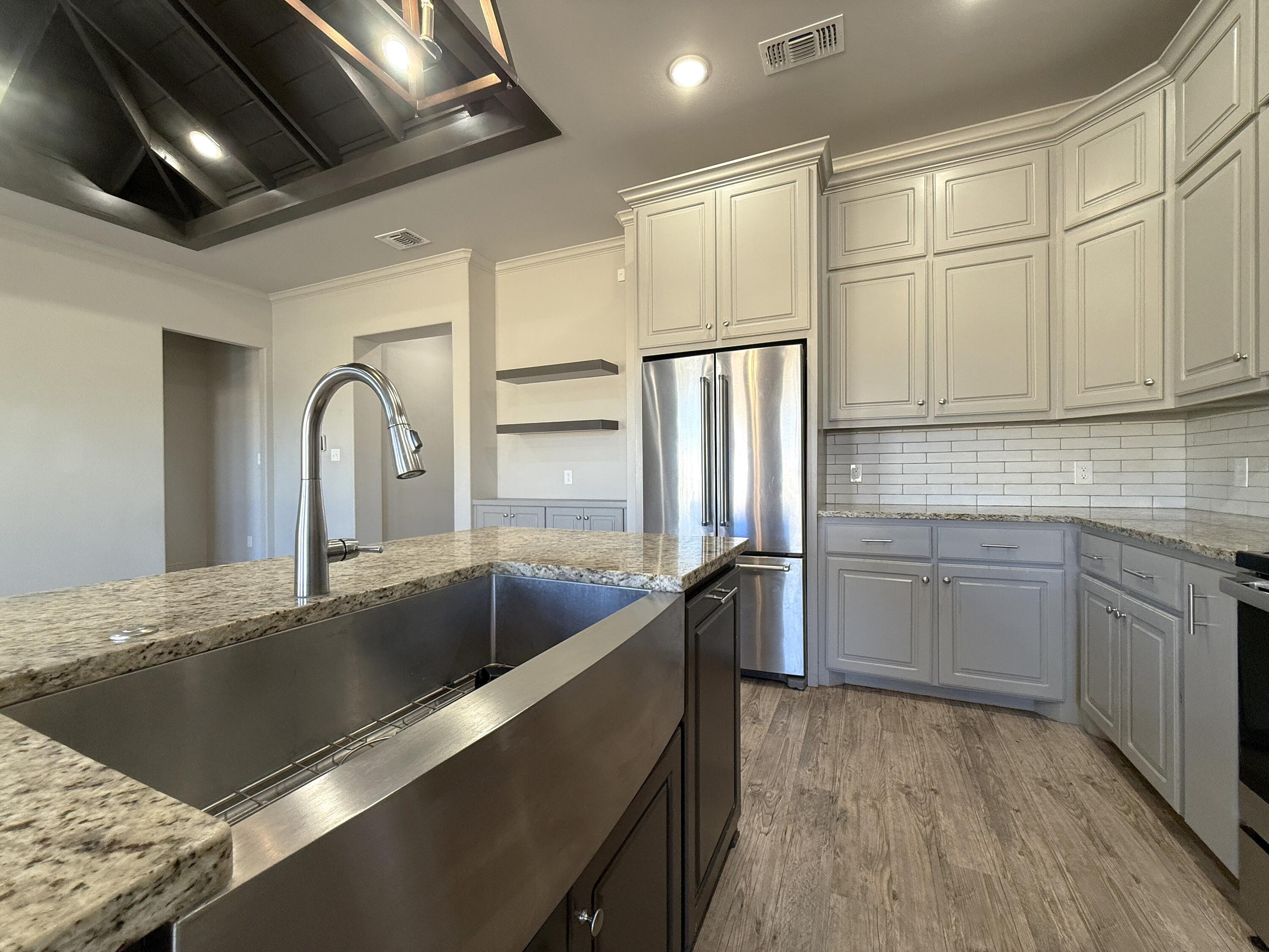 7504 87th Street Lubbock, TX 79424 - Photo 11 of 33 a kitchen with stainless steel appliances granite countertop a sink a stove and refrigerator