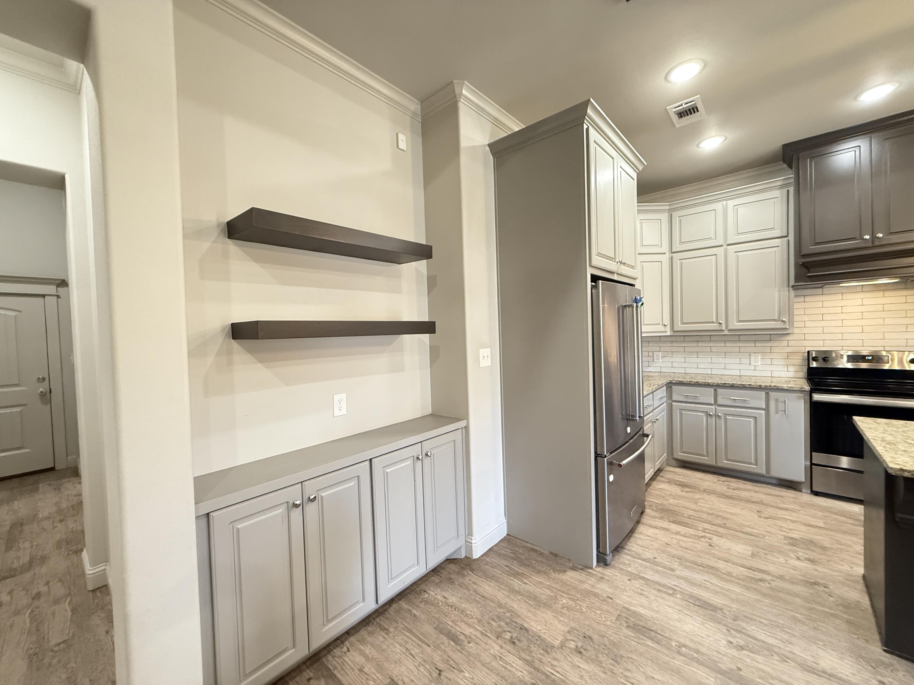 7504 87th Street Lubbock, TX 79424 - Photo 15 of 33 a kitchen with white cabinets and refrigerator