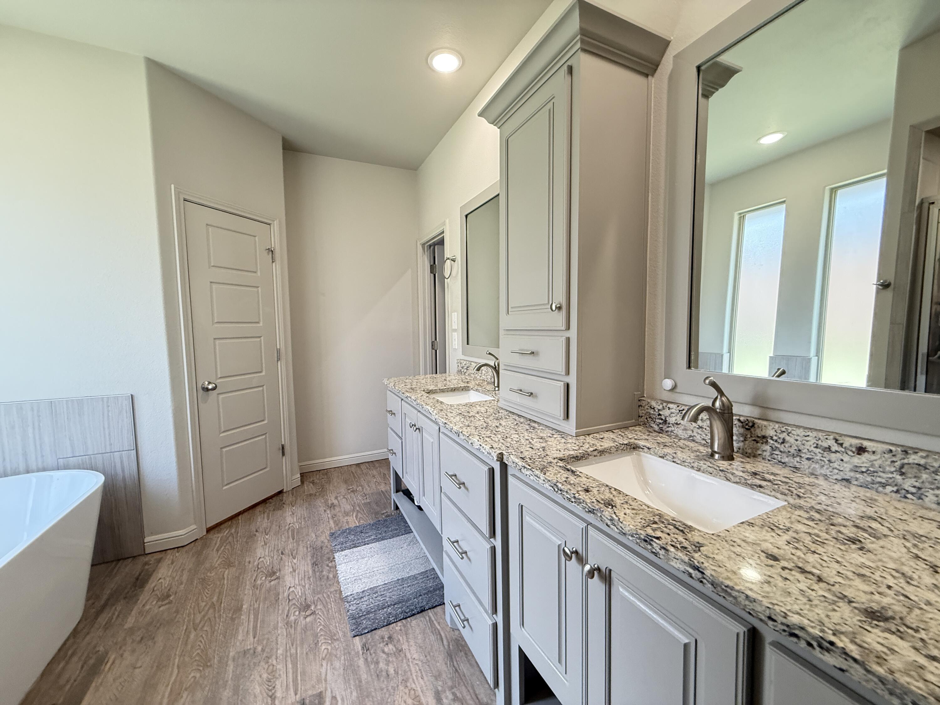 7504 87th Street Lubbock, TX 79424 - Photo 18 of 33 a bathroom with a granite countertop double vanity sink and mirror