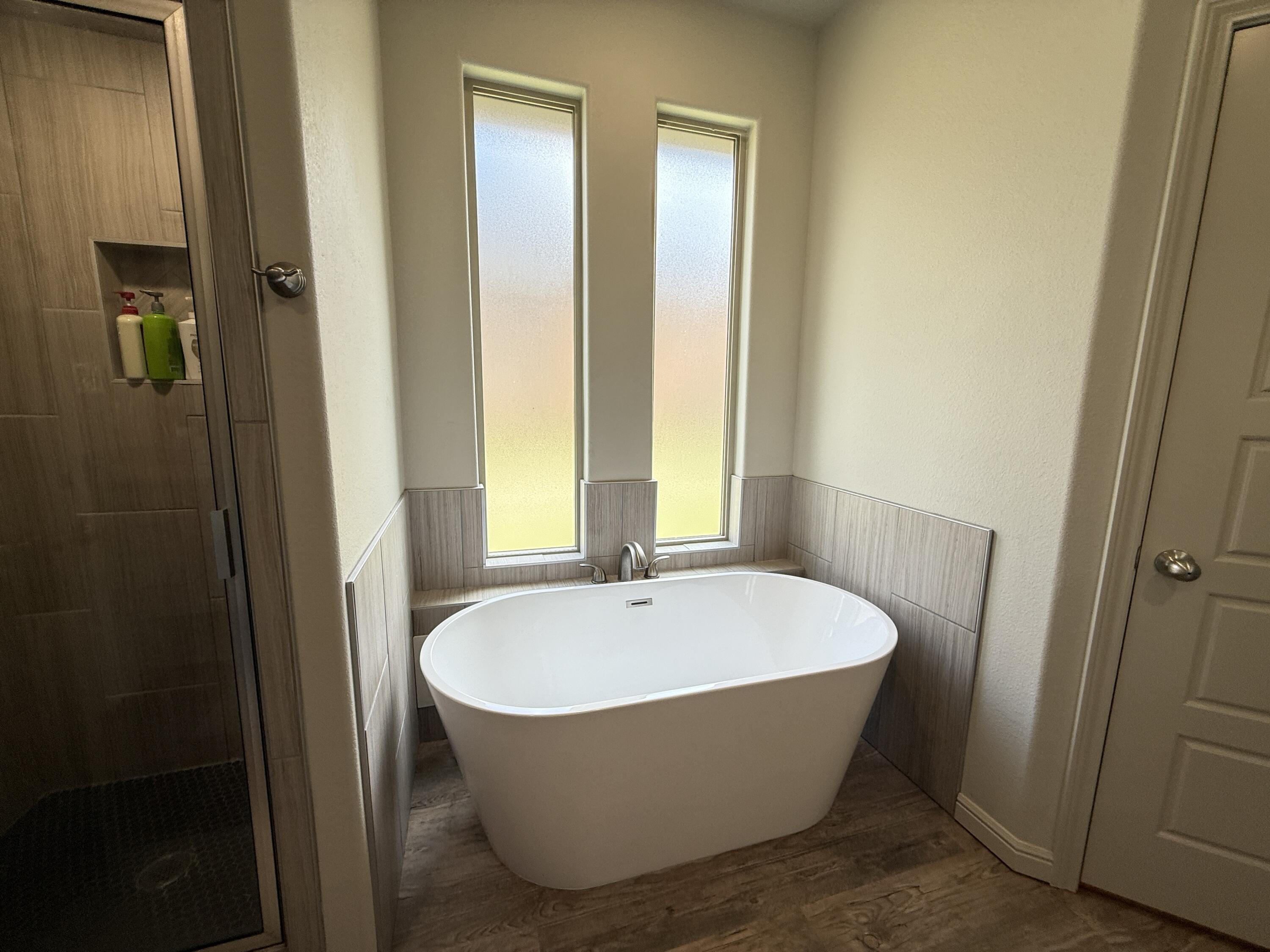 7504 87th Street Lubbock, TX 79424 - Photo 19 of 33 a bathroom with bathtub and window