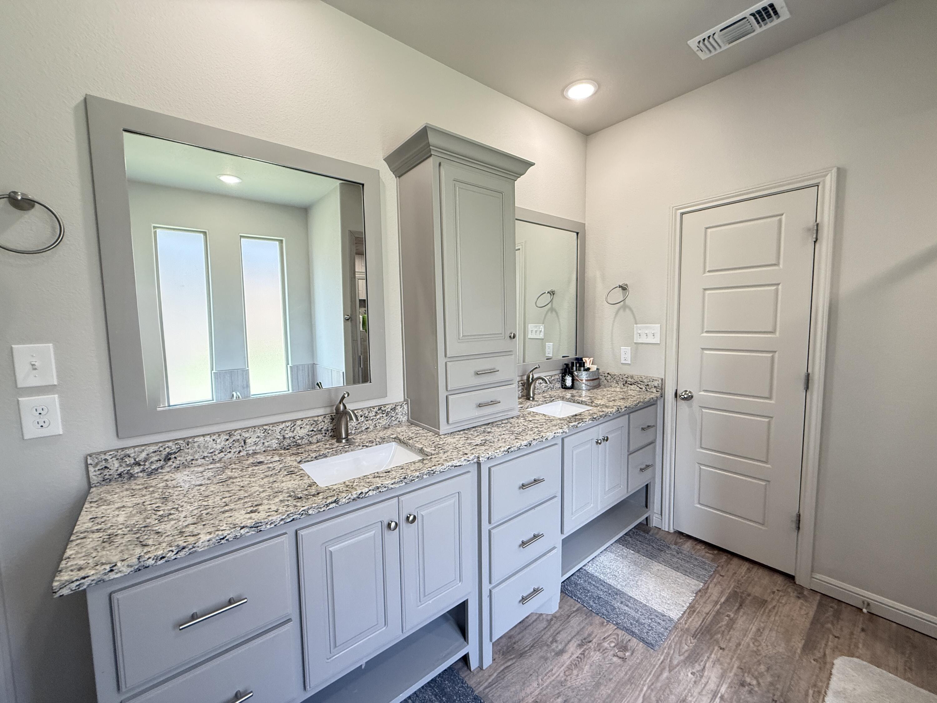 7504 87th Street Lubbock, TX 79424 - Photo 21 of 33 a bathroom with a granite countertop double vanity sink mirror and