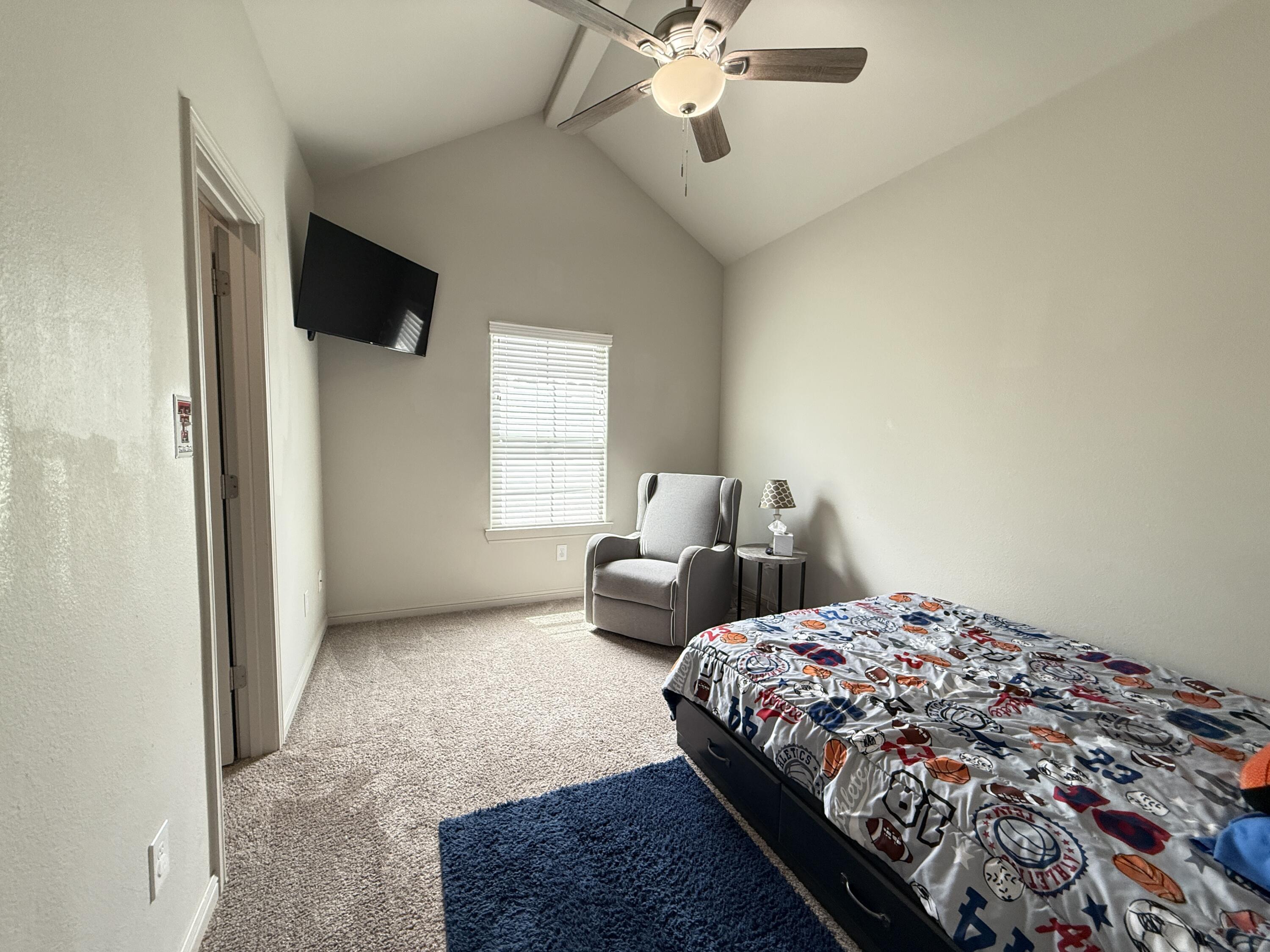 7504 87th Street Lubbock, TX 79424 - Photo 22 of 33 a bedroom with a bed and a chandelier