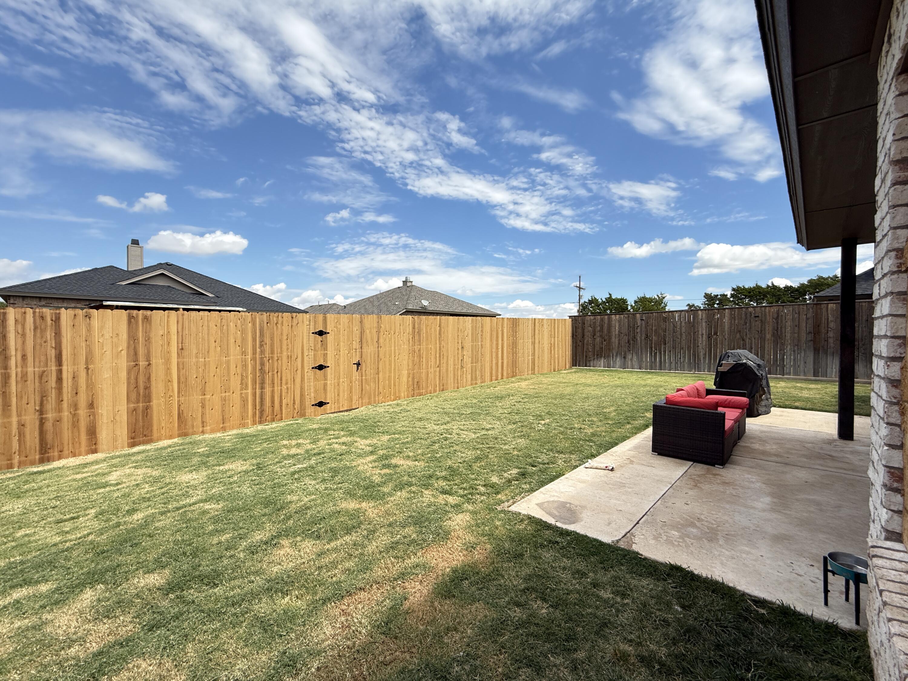7504 87th Street Lubbock, TX 79424 - Photo 27 of 33 a view of a patio with table and chairs with wooden fence