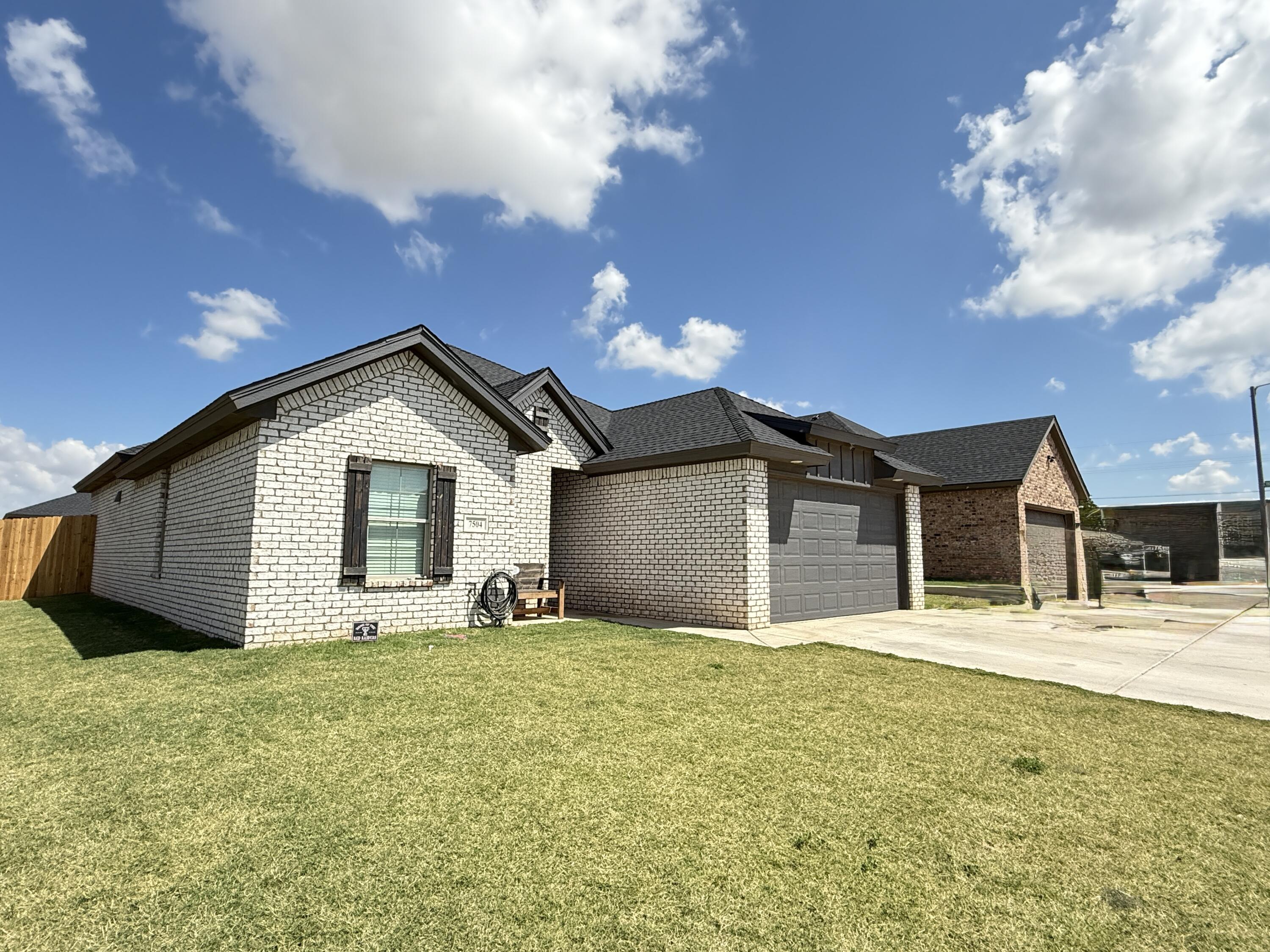 7504 87th Street Lubbock, TX 79424 - Photo 33 of 33 a front view of a house with yard and garage