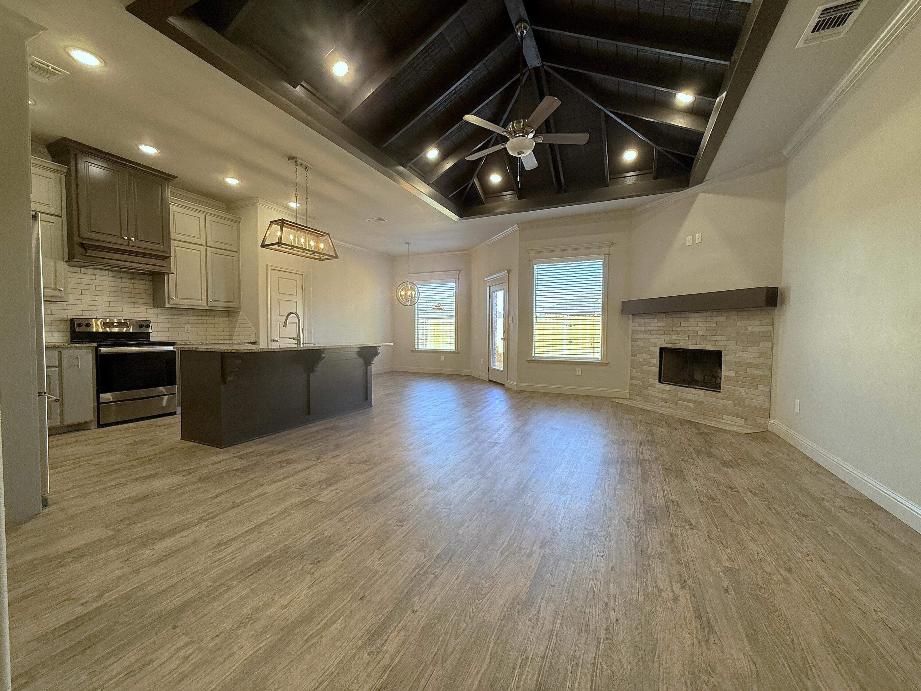 7504 87th Street Lubbock, TX 79424 - Photo 4 of 33 an empty room with wooden floor and fireplace