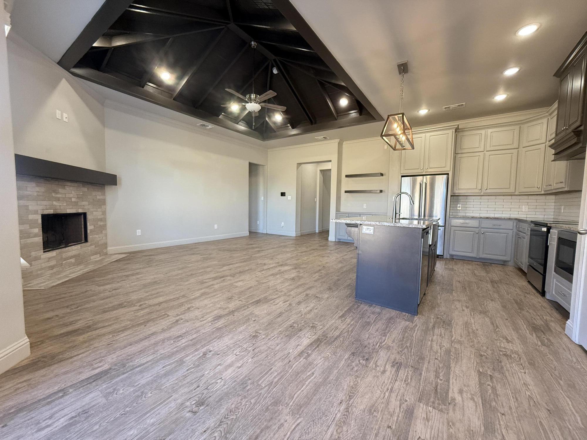 7504 87th Street Lubbock, TX 79424 - Photo 6 of 33 a room with stainless steel appliances kitchen island granite countertop a stove top oven a sink with wooden floors