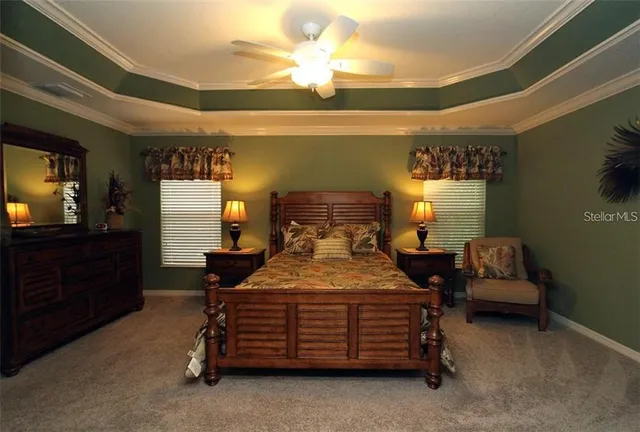 a bedroom with a bed and a flat tv screen on dresser