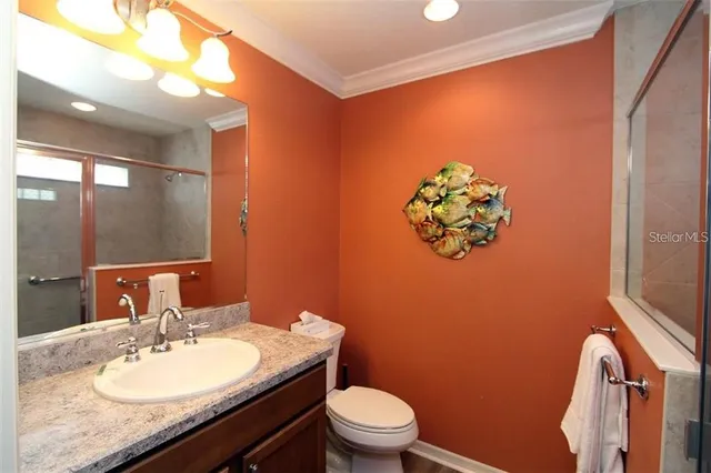 a bathroom with a granite countertop sink a toilet a mirror and shower curtain