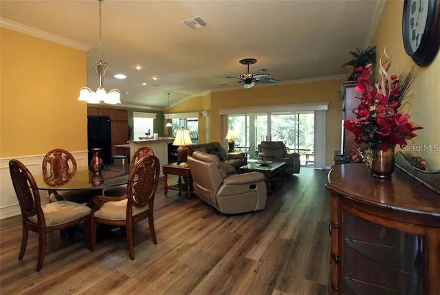 a living room with furniture a chandelier a fireplace and a potted plant