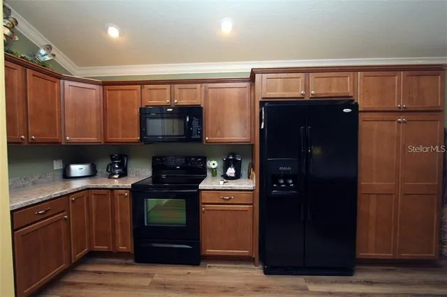 a kitchen with a refrigerator and a stove top oven