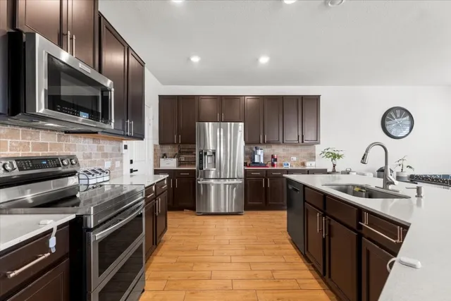 a kitchen with a sink stainless steel appliances and cabinets