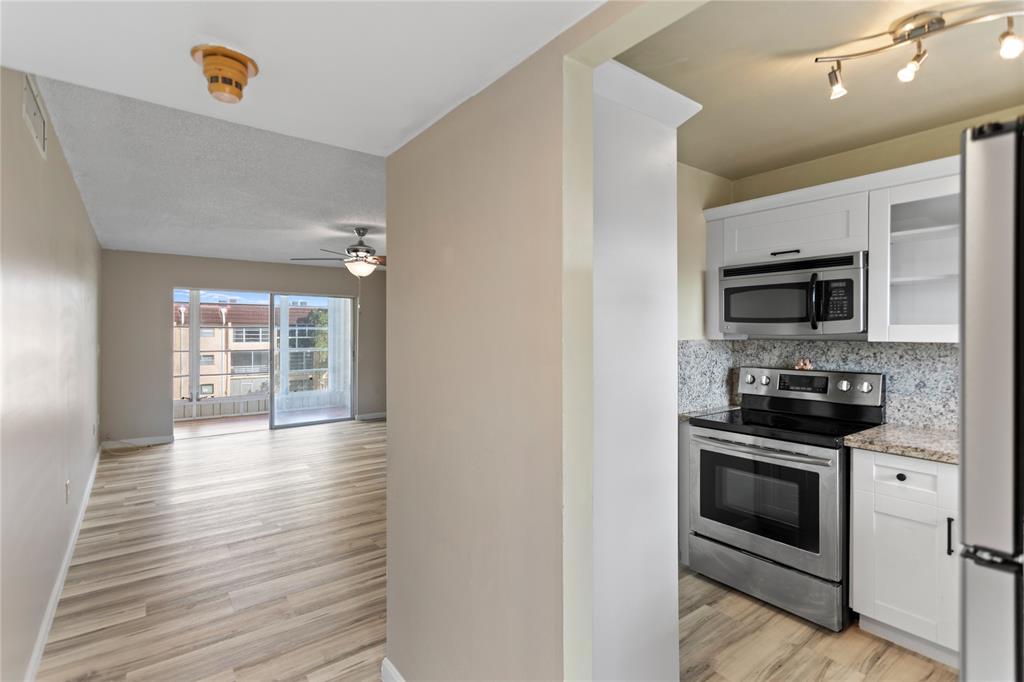 a kitchen with stainless steel appliances a stove a microwave and white cabinets