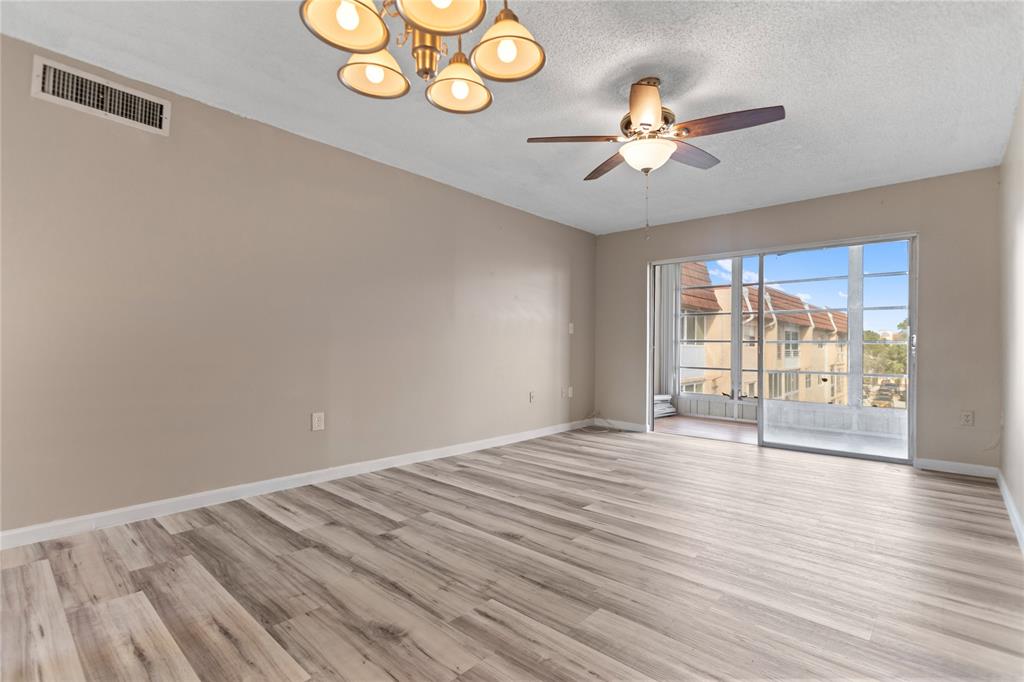 2720 North Pine Island Road, Unit 307 Sunrise, FL 33322 - Photo 18 of 40 a view of an empty room with wooden floor and a window
