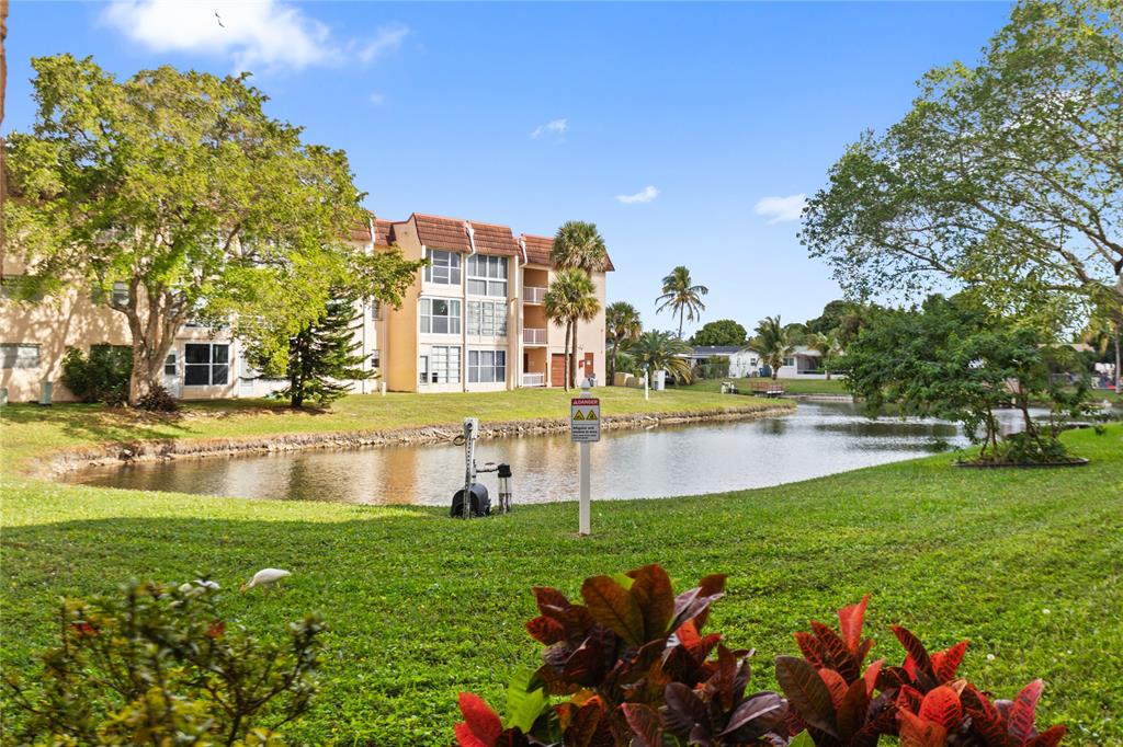 2720 North Pine Island Road, Unit 307 Sunrise, FL 33322 - Photo 5 of 40 a view of a lake with a building and a big yard