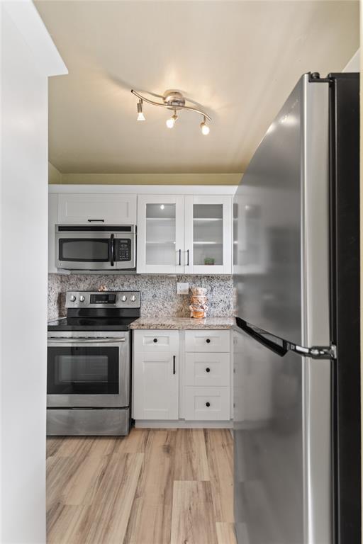 2720 North Pine Island Road, Unit 307 Sunrise, FL 33322 - Photo 9 of 40 a kitchen with granite countertop white cabinets and stainless steel appliances
