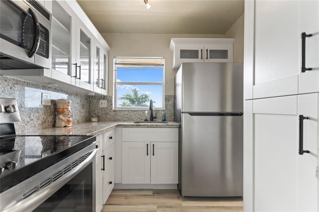2720 North Pine Island Road, Unit 307 Sunrise, FL 33322 - Photo 10 of 40 a kitchen with stainless steel appliances granite countertop a refrigerator a sink and a stove