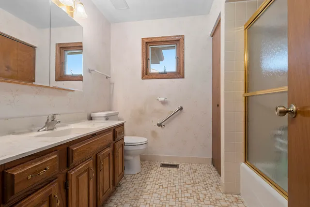 a bathroom with a sink a toilet and shower