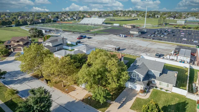 an aerial view of a house with a garden and lake view