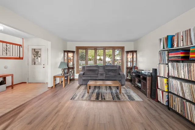 a very nice looking living room with a large window and a book shelf