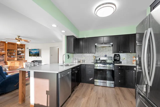 a kitchen with stainless steel appliances granite countertop a sink stove and refrigerator