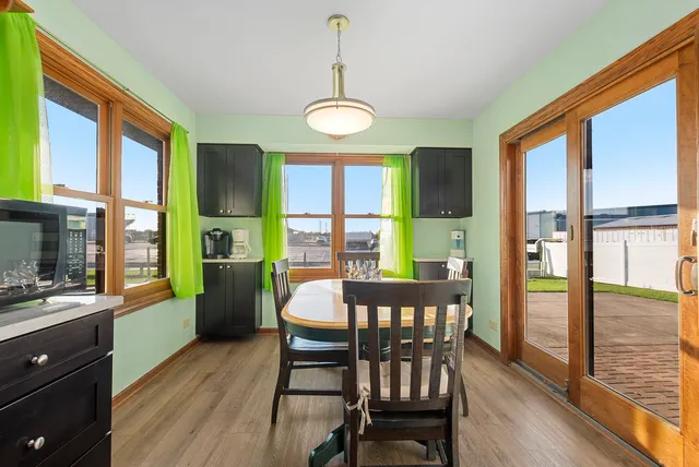a view of a dining room with furniture a chandelier and wooden floor