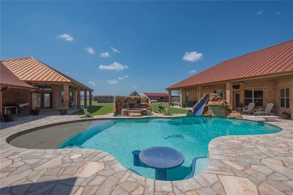 a view of a house with backyard sitting area and swimming pool