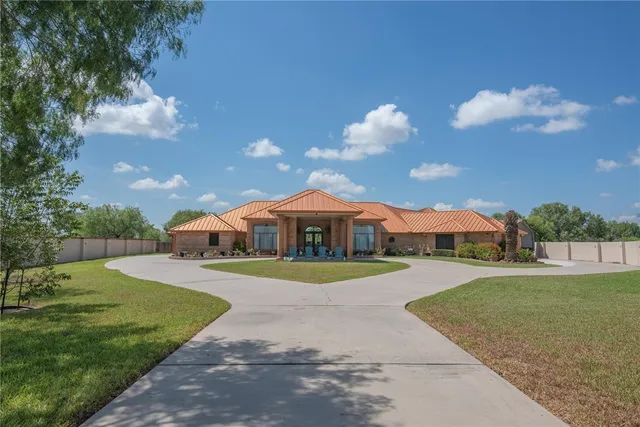 a front view of a house with a yard and trees