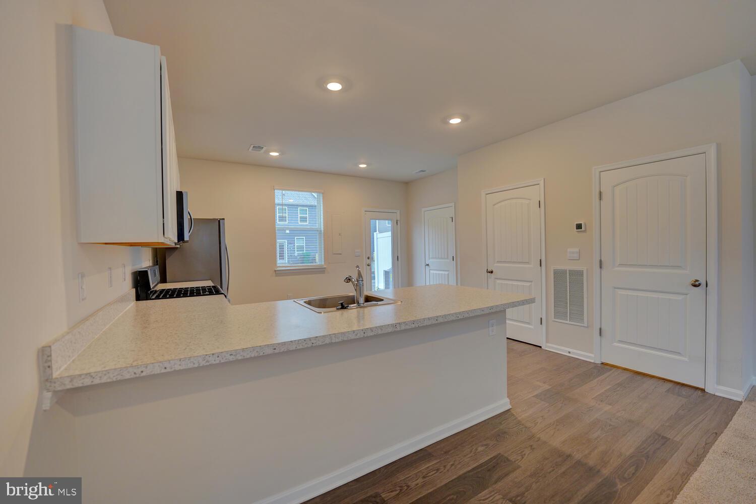 21 Crowberry Drive Magnolia, DE 19962 - Photo 13 of 38 a view of kitchen island a sink wooden floor and living room view