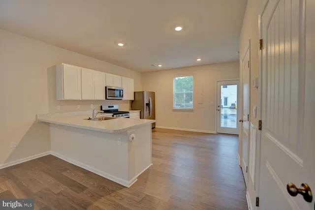 a view of kitchen with sink and wooden floor